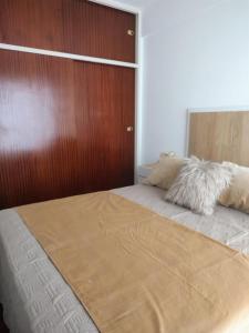 a bedroom with a large bed with a wooden wall at Bienestar Haedo in Mariano J. Haedo