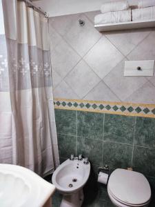a bathroom with a toilet and a sink at Bienestar Haedo in Mariano J. Haedo