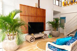 勒吉安的住宿－Shray Villa. Legian，一间配有电视和棕榈树的客厅