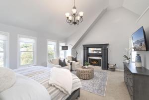 a white bedroom with a bed and a fireplace at 3813 Point Break home in Pacific Grove