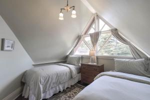 a attic bedroom with two beds and a window at 3812 Little House home in Pacific Grove