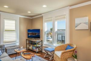 a living room with windows and a tv at 3788 The Seagull's Nest home in Pacific Grove