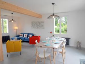 - un salon avec une table, des chaises et un canapé dans l'établissement Cottage, St Pabu, à Kervasdou