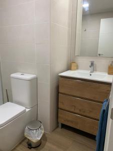 a bathroom with a toilet and a sink and a mirror at Apartamento Central D in Algeciras