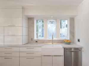 eine weiße Küche mit einem Waschbecken und einem Fenster in der Unterkunft 3817 Caledonia Bay Lookout home in Pacific Grove