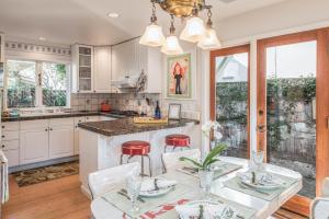 cocina con armarios blancos, mesa y sillas en 3743 Pelican Peaks home en Pacific Grove