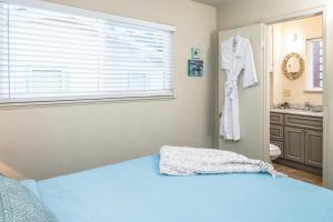 a bedroom with a blue bed and a bathroom at 3804 Mermaid Loft home in Pacific Grove