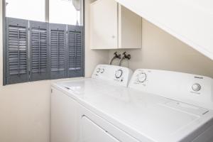 a white laundry room with a washer and dryer at 3804 Mermaid Loft home in Pacific Grove +26 photos