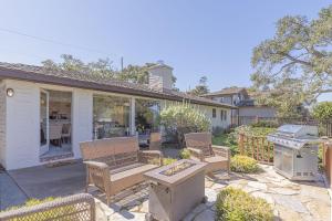 a patio with chairs and a grill in a yard at 3786 Adobe by the Sea home in Pebble Beach