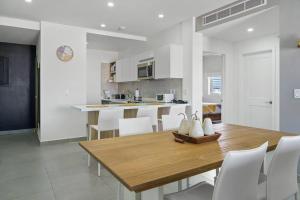 cocina y comedor con mesa de madera y sillas en Milateo Suite en Oranjestad