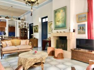 un soggiorno con camino e TV di Traditional House at Aegina Port a Città di Egina