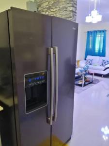 um frigorífico de aço inoxidável numa sala de estar em Hermoso y cómodo apartamento familiar en Ciudad Juan Bosch em Los Paredones