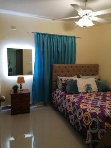 a bedroom with a bed and a ceiling fan at Hermoso y cómodo apartamento familiar en Ciudad Juan Bosch in Los Paredones