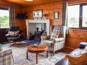 a living room with furniture and a fireplace at Catkin Lodge - Uk39646 in Lunga