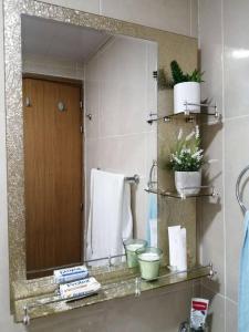 a bathroom with a mirror and a sink at Hermoso y cómodo apartamento familiar en Ciudad Juan Bosch in Los Paredones