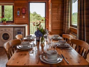 a wooden table with plates and dishes on it in a kitchen at Catkin Lodge - Uk39646 in Lunga