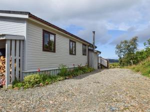 a white house with a gravel road next to it at Catkin Lodge - Uk39646 in Lunga