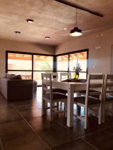 a dining room with a white table and chairs at La Pasionaria Casa de Campo in Agua de Oro