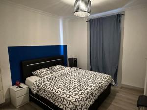 um quarto com uma cama com uma cabeceira azul em QDB Hyper Centre Geneve em Genebra
