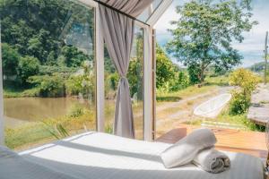 uma cama em frente a uma janela com vista em นอนนิ่ง อิงดาว em Ban Pha Sai