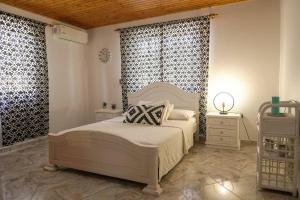 a bedroom with a white bed and a window at Blue Primavera in Oranjestad
