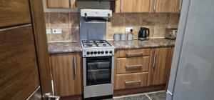 a kitchen with a stove and wooden cabinets at J Lodge in Northampton