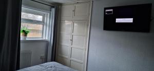 a bedroom with a white cabinet and a window at J Lodge in Northampton