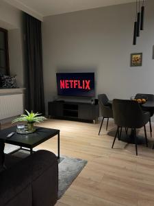 uma sala de estar com uma televisão com o sinal netflix em Apartament Złota winda Tuwima em Lódź