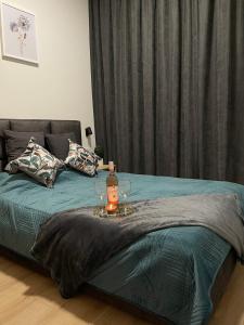 uma cama com uma garrafa de vinho e copos em Apartament Złota winda Tuwima em Lódź