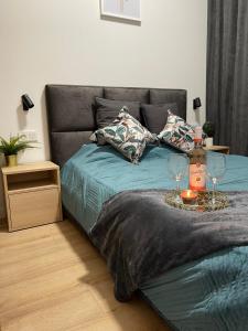 uma cama com uma mesa com dois copos de vinho em Apartament Złota winda Tuwima em Lódź