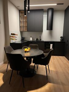 uma sala de jantar com uma mesa e cadeiras numa cozinha em Apartament Złota winda Tuwima em Lódź