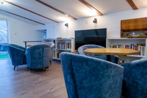 Gora Apartments Premium Lodge - Stara Planina في Balta Berilovac: غرفة انتظار مع كراسي وطاولة وتلفزيون