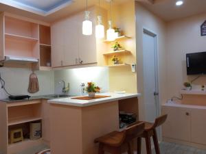 a kitchen with a counter with two chairs and a sink at Mistow BriaMagenta Condo in Cagayan de Oro