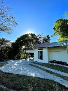 mały biały dom z drzewami w tle w obiekcie Eucalyptus Cabin Boquete w mieście Bajo Boquete