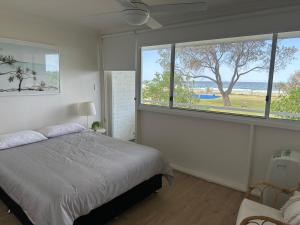 a bedroom with a bed and a large window at Nalu - Hosted by Burleigh Letting in Gold Coast