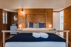 a bedroom with a large bed with a wooden wall at Encosta d´Óbidos in Óbidos