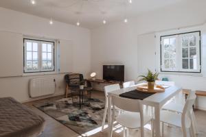 Encosta d´Óbidos في أوبيدوس: غرفة معيشة مع طاولة وكراسي بيضاء
