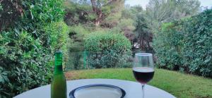 un bicchiere di vino accanto a una bottiglia di vino di Addaia Coves Noves Playa Arenal d'en Castell a Es Mercadal