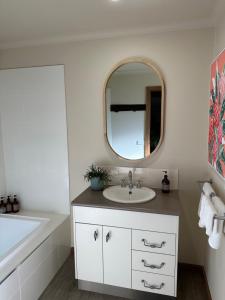 a bathroom with a sink and a mirror at Daysend Cottages in Merrijig