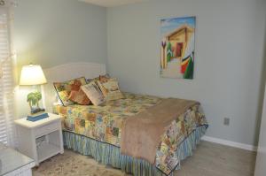 a bedroom with a bed and a table with a lamp at Gulf front condo in Panama City Beach +22 photos