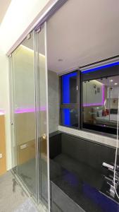 a bathroom with a glass shower and a window at 宜蘭頭城鎮 Alice 高級溫泉雙-四人套房海景度假 in Hsin-hsing