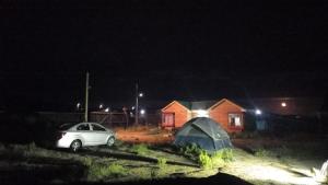 une voiture garée devant une maison la nuit dans l'établissement CABAÑA RURAL PICHIDANGUI, à Pichidangui