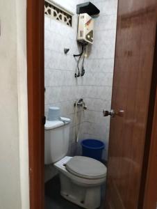 a small bathroom with a toilet and a fan at Villa Landis Resort in Pacet