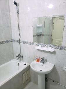 een badkamer met een wastafel, een bad en een spiegel bij Dar maria in Fès