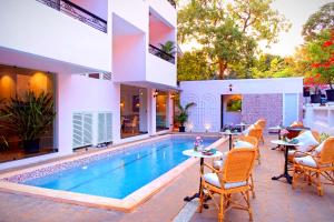 een villa met een zwembad en een patio bij Mademoiselle Boutique Resort and Cafe in Vagator