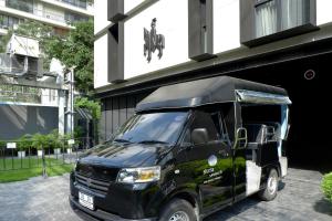 een zwarte truck geparkeerd voor een gebouw bij Walton Suites Sukhumvit in Bangkok