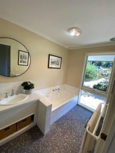 a bathroom with a tub and a sink and a mirror at Mount Hope Estate Vineyard in Dixons Creek