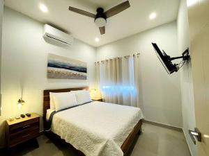 1 dormitorio con 1 cama y ventilador de techo en Casa Lapa Roja, en Playa Hermosa