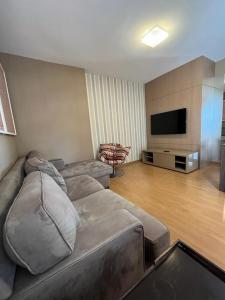 sala de estar con sofá y TV de pantalla plana en Hospede-se B21 Convention Flat Particular en Brasilia