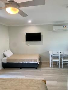 a bedroom with a bed and a flat screen tv at Singleton Valley Accommodation in Singleton
